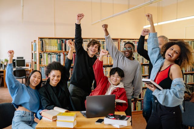 Group of happy students with fists in air 