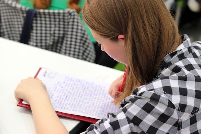 Female student writing essay on paper