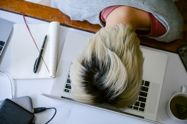 student with head down on computer